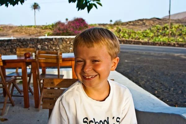 Pojken som sitter i en utomhus restaurang — Stockfoto