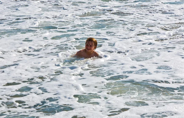 Χαριτωμένο αγόρι έχει διασκέδαση στα κύματα — Φωτογραφία Αρχείου