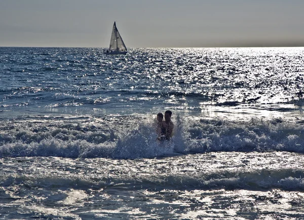 Купання на заході сонця в хвилях на пляжі — стокове фото