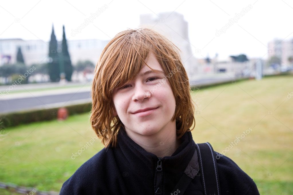 Young boy with red hair is smiling and looking happy