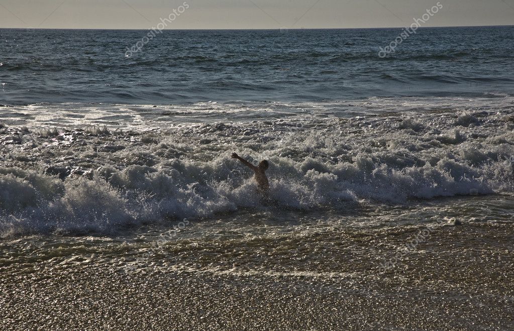 Bathing in sunset in waves at the beach — Stock Photo © Hackman #5799477
