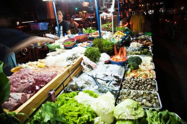Fresh fish and vegetables are offered at the night market clipart