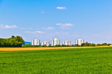 Housing area in rural landscape with fields clipart