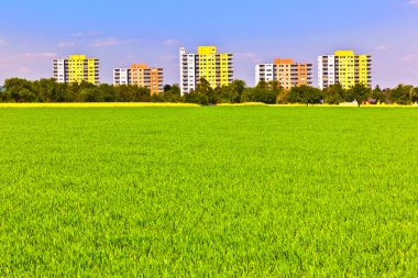 Housing area in rural landscape with fields clipart