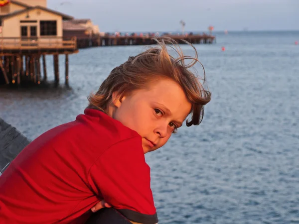 Trieste jongen in zonsondergang — Stockfoto