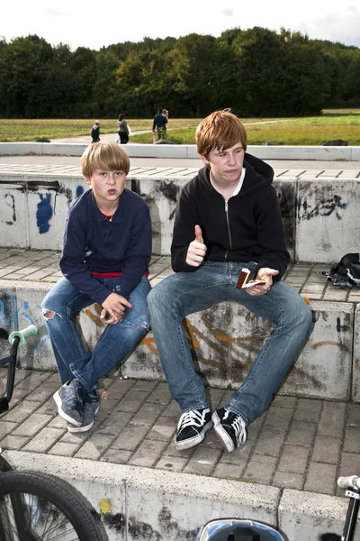 Fajne chłopców siedzi na kamieniu — Zdjęcie stockowe
