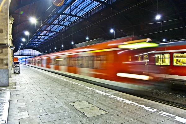 Train im motion enters the station — Stock Photo, Image