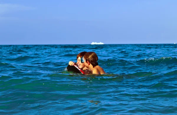 Hermanos arrastrándose con la tabla de surf a través del mar —  Fotos de Stock