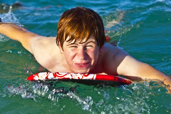 Ung pojke kryper på surfbräda — Stockfoto