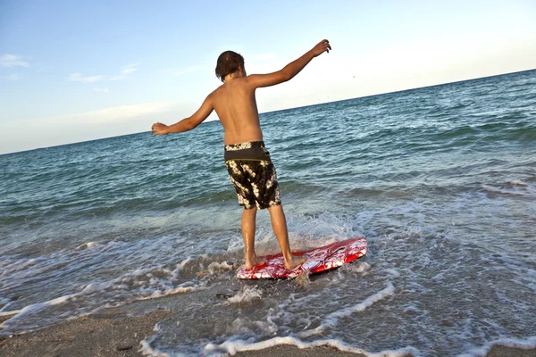 Pojke att lära sig surfa på stranden — Stockfoto
