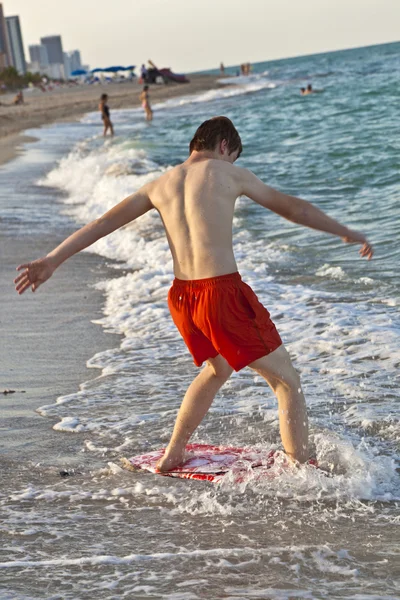 Menino aprendendo a surfar na praia — Fotografia de Stock