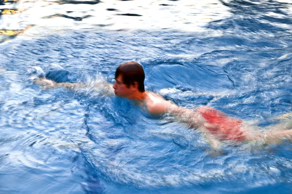 Úszás a medencében az esti fiú — Stock Fotó