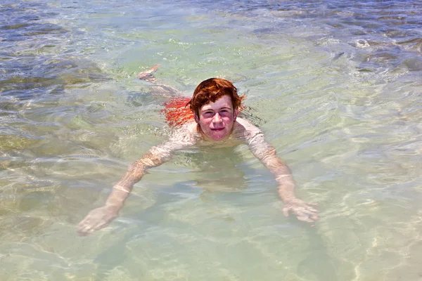 Junge schwimmt im klaren Ozean — Stockfoto