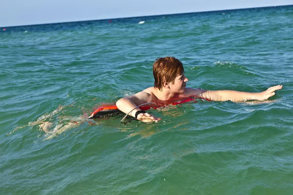 Boy in a swim ring has fun in the ocea — Stock Photo, Image