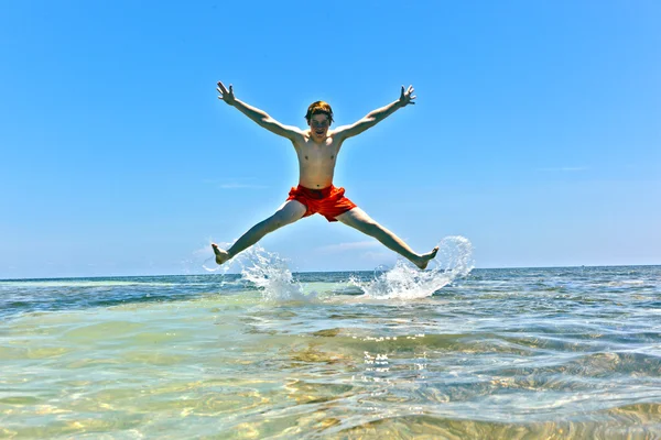 Junge springt auf Sandbank — Stockfoto