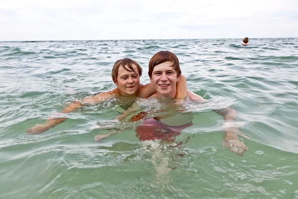 Chłopcy świetnie się bawią w piękne czyste morze — Zdjęcie stockowe