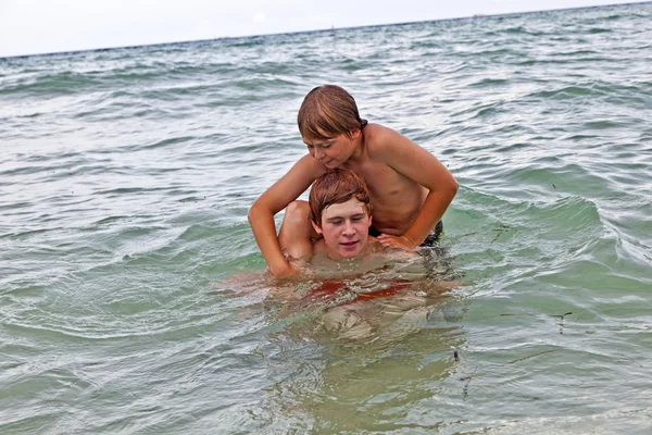 Jongens met plezier in de prachtige heldere zee — Stockfoto