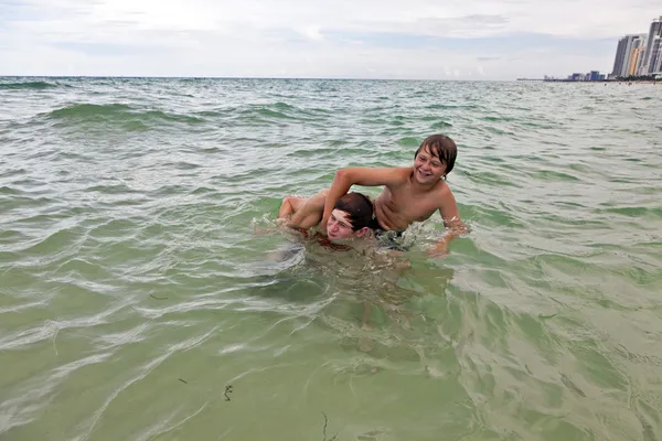 Хлопчики розважаються в прекрасному чистому морі, граючи в пікап — стокове фото