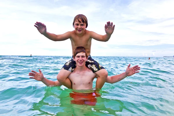Хлопчики розважаються в прекрасному чистому морі, граючи в пікап — стокове фото