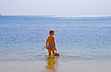 Boy walking at the beach with coconut