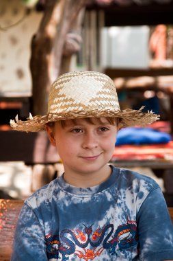 Çocuk hasır şapka ile bir açık hava restaura güneşe bir dinlenme vardır