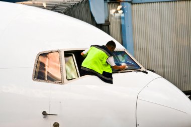 işçi uçağın kokpit camını temizleme