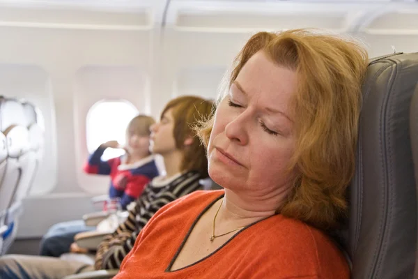 Frau schläft im Flugzeug — Stockfoto