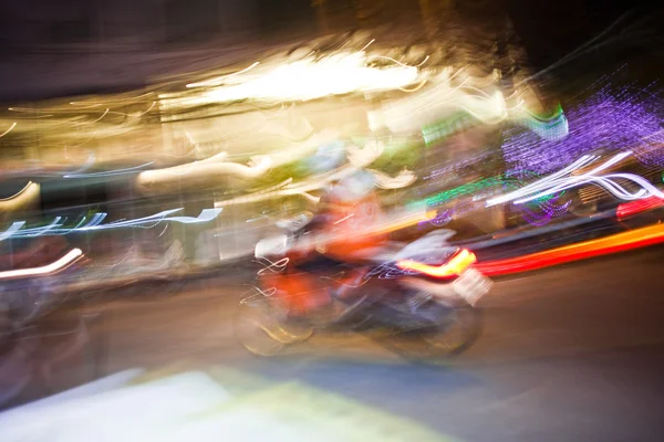 Motobike driver by night with abstract lights — Stock Photo, Image