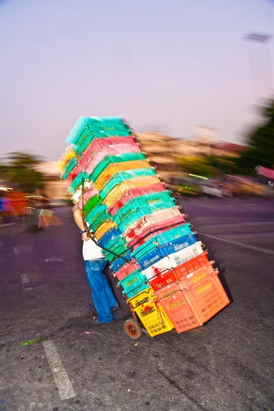 Uomo che trasporta scatole di plastica — Foto Stock
