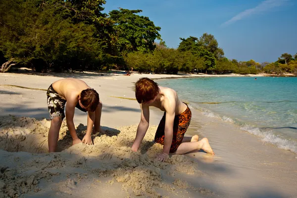 Młodzi chłopcy cieszą się gra na plaży i budynku w postać — Zdjęcie stockowe