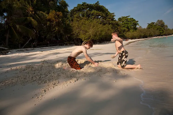 Unga pojkar njuter på stranden och bygga figur — Stockfoto