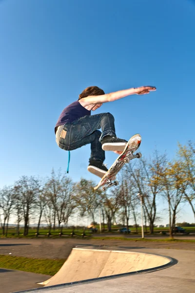 Menino indo para o ar com o skate board — Fotografia de Stock