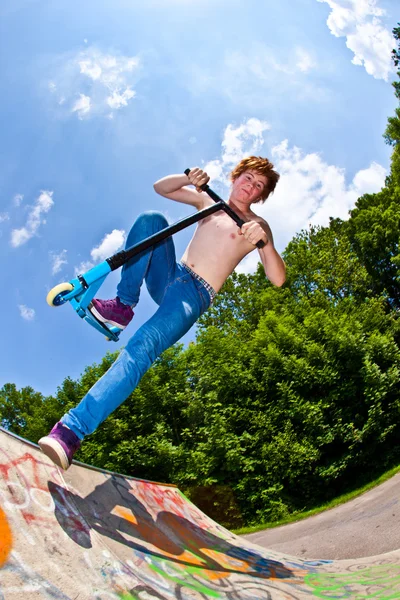 Jeune garçon va dans les airs avec un scooter — Photo