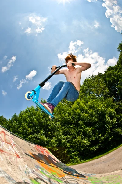 Jeune garçon va dans les airs avec un scooter — Photo