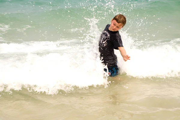 Chłopiec bawi się kokosem na pięknej plaży — Zdjęcie stockowe