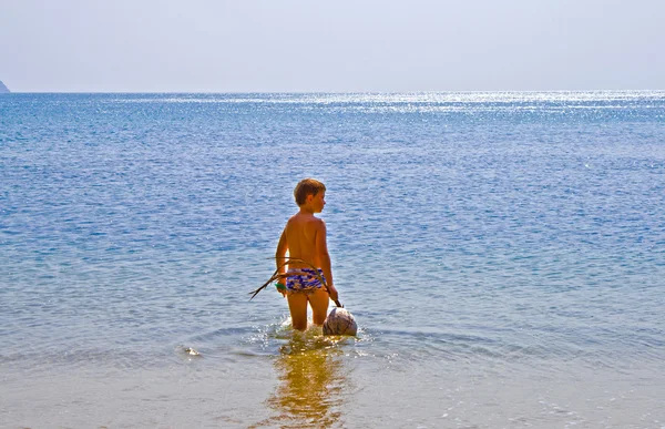 Pojke promenader på stranden med kokos — Stockfoto