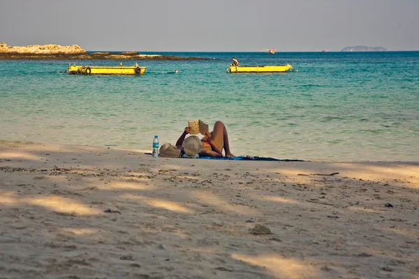 Žena čte knihu na nádherné pláži — Stock fotografie