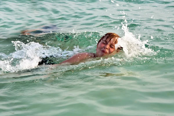 Kleiner Junge genießt das Schwimmen im klaren, warmen Salzwasser im Meer — Stockfoto