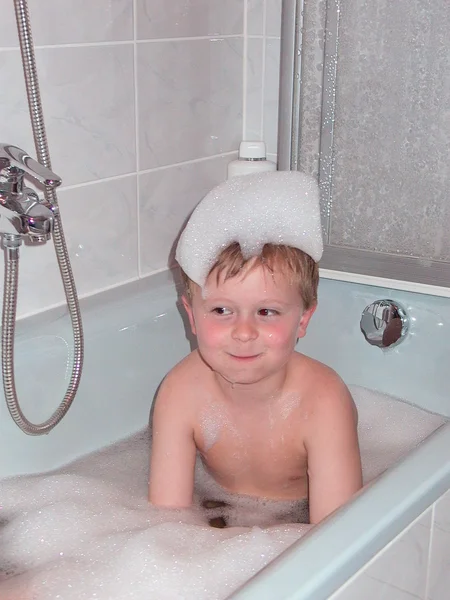 Niño en el tubo de baño con espuma en la cabeza —  Fotos de Stock