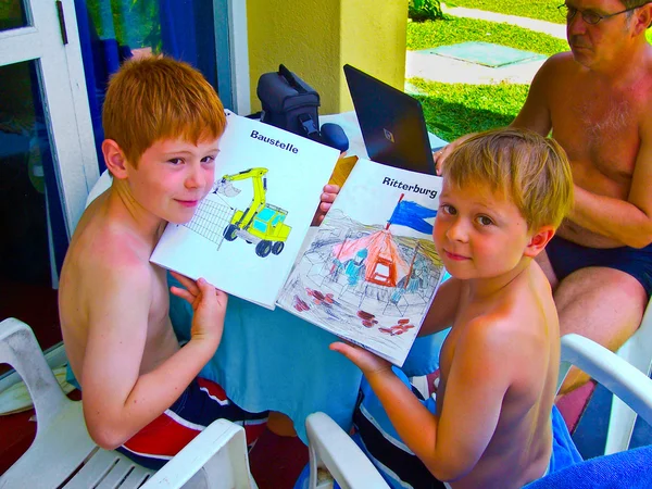 Kinderen schilderij in het boek terwijl hun vader op de la werkt — Stockfoto