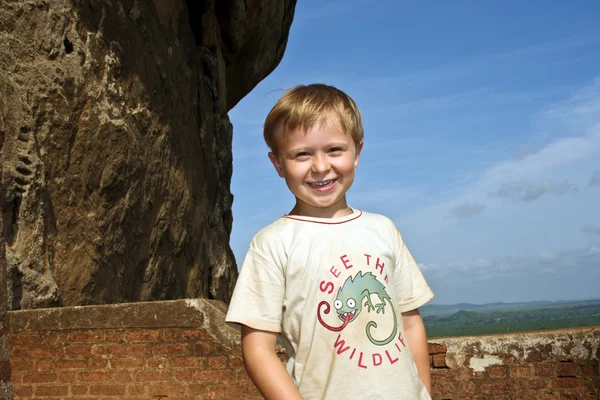Niño con el pelo rubio disfruta de visitar los lugares extranjeros y sonreír —  Fotos de Stock