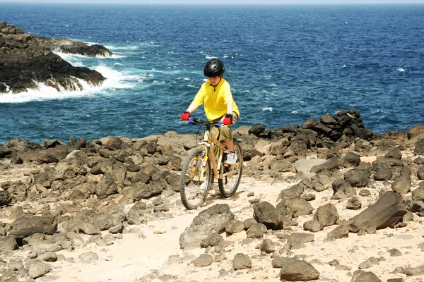 Dreng ridning hans mountainbike offroad og gøre tricks - Stock-foto