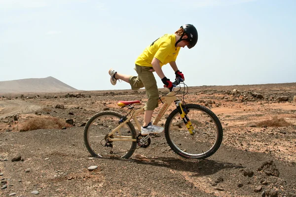 Pojke ridning hans mountainbike offroads och gör tricks — Stockfoto