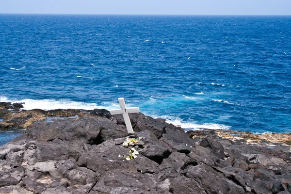 Kreuz für einen Toten auf einem Felsen am Meer — Stockfoto