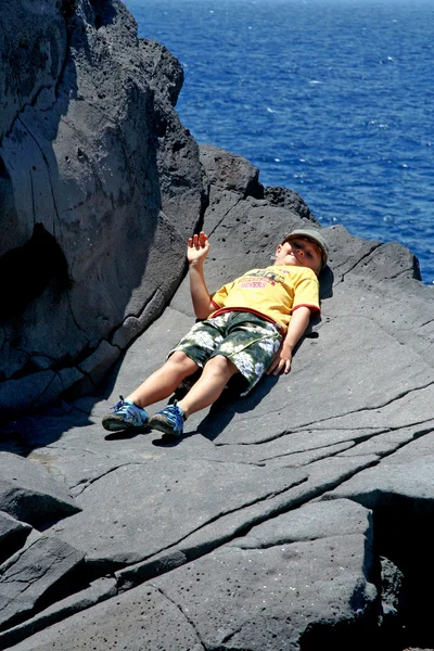 Menino feliz encontra-se na rocha — Fotografia de Stock