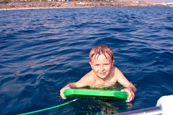 Niño está surfeando en el océano —  Fotos de Stock