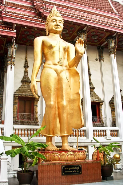 Standing Buddah in a temple in Bangkok is giving a handsign — Stock Photo, Image