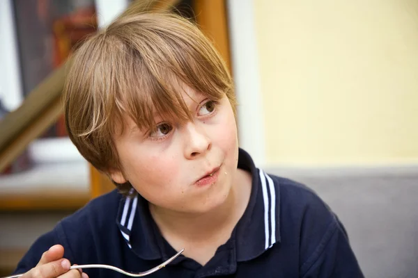 Eating boy is looking astonished and interested — Stock Photo, Image