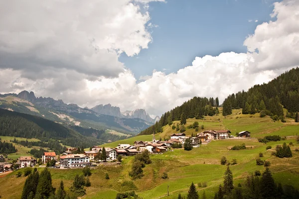 Villaggio, prati e montagne nelle Alpi — Foto Stock