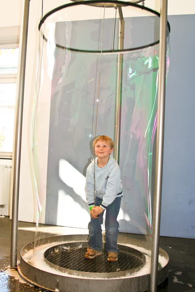 Kind heeft plezier in een enorme zeepbel machine — Stockfoto